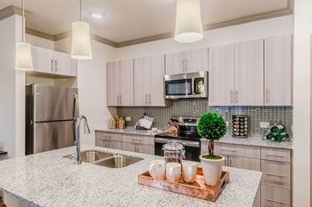 A kitchen with a granite countertop and a refrigerator.